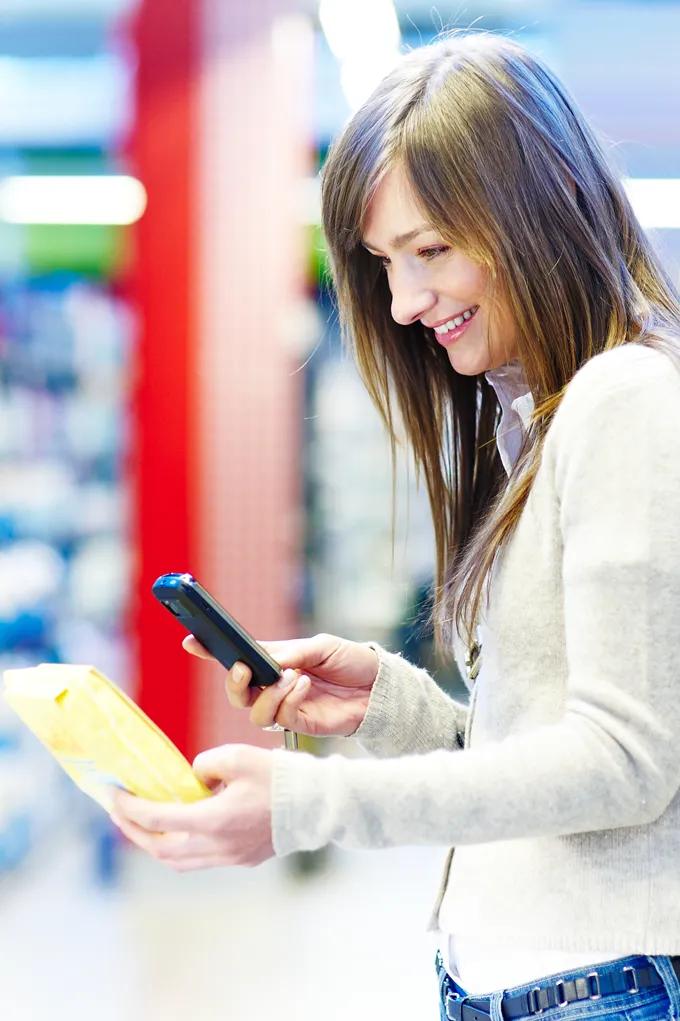 Eine Frau scannt einen QR Code im Supermarkt