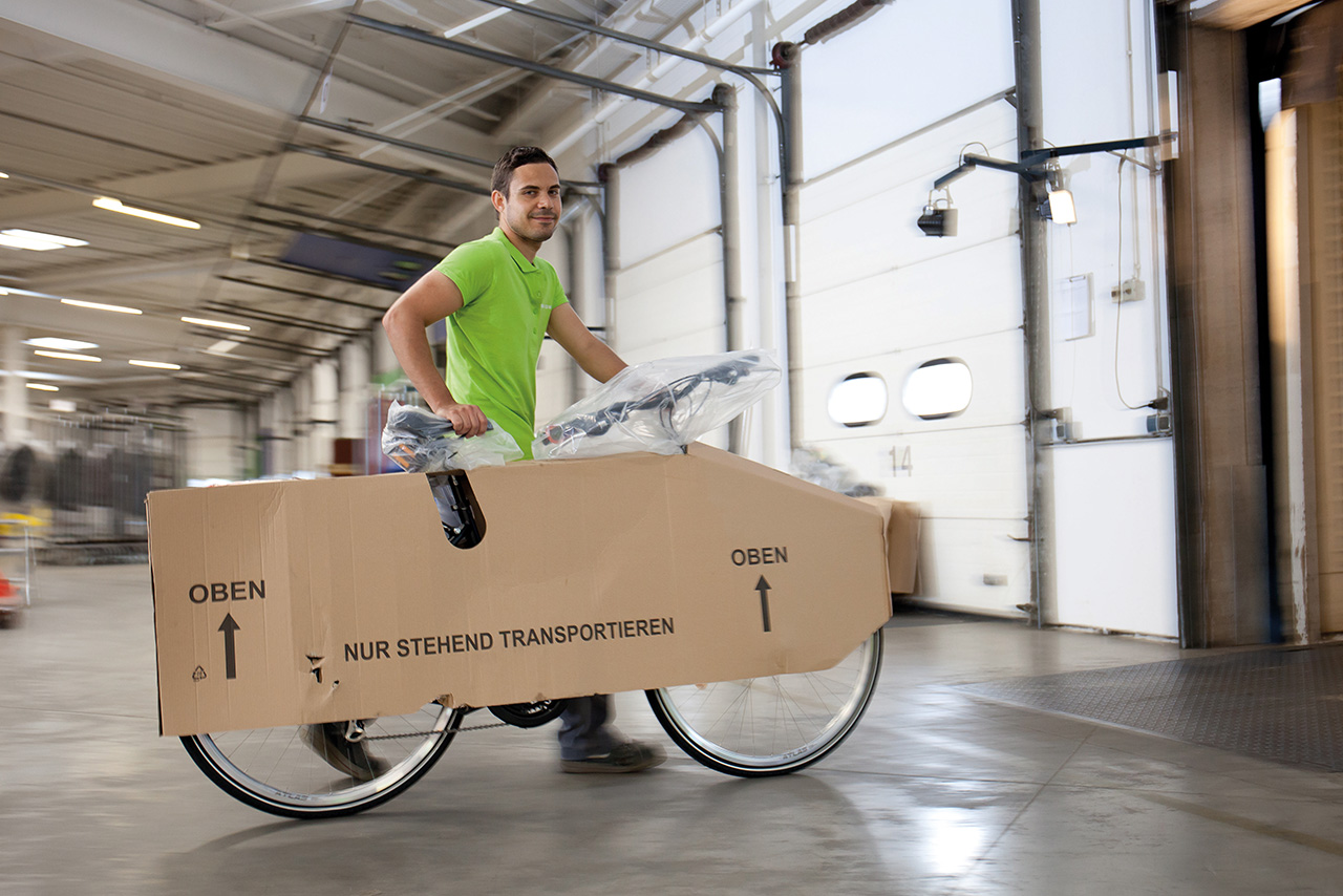 Logwin Mitarbeiter schiebt ein verpacktes Fahrrad