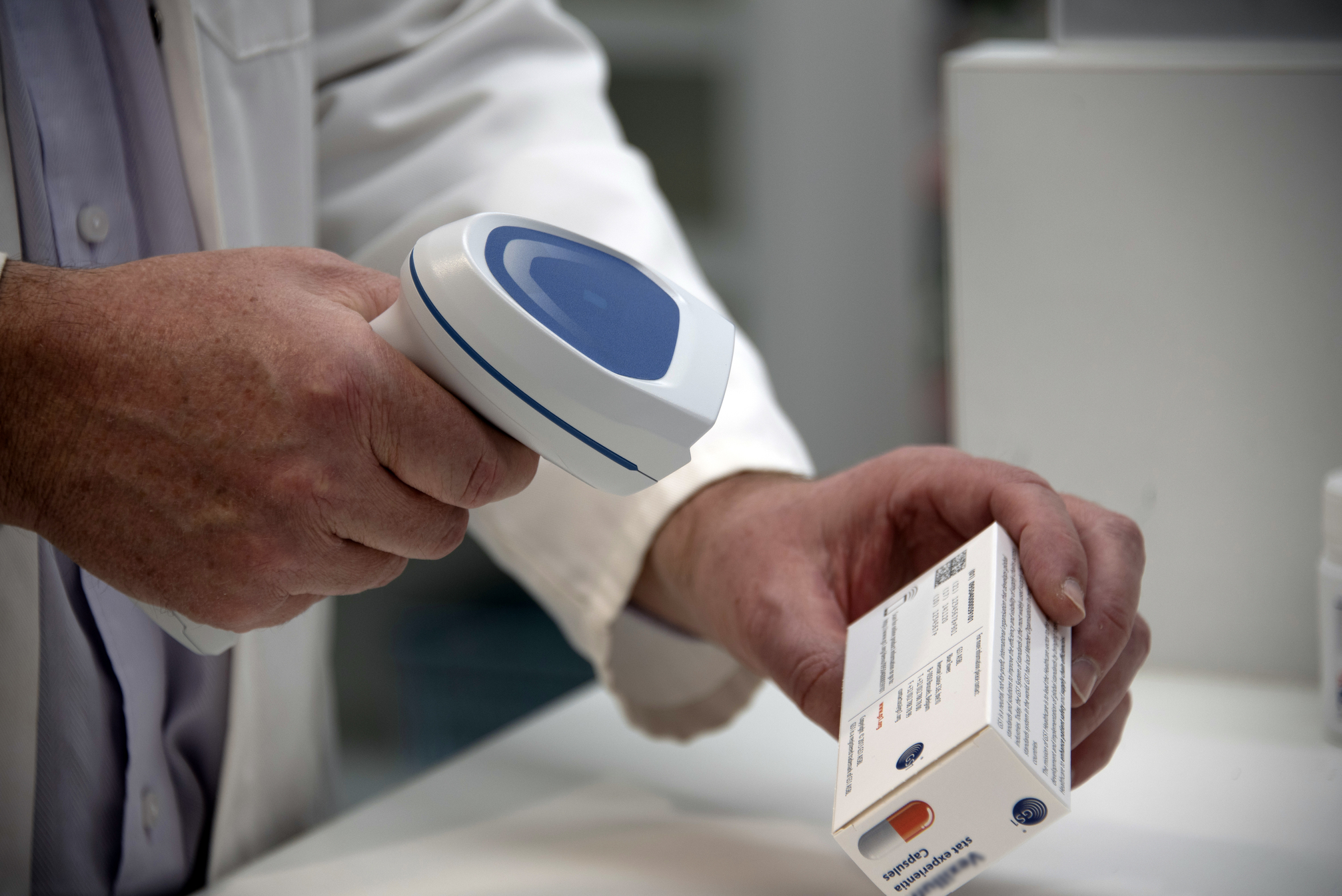 Person scannt Medikamentenpackung ein