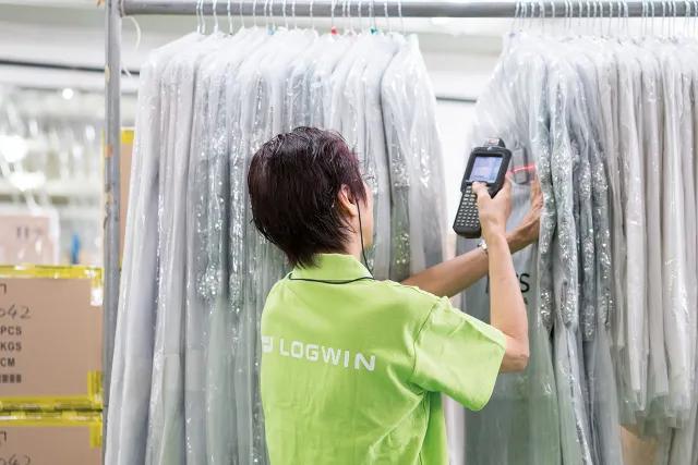 Logwin Mitarbeiter erfasst automatisiert Kleidungsstücke auf einer Kleiderstange