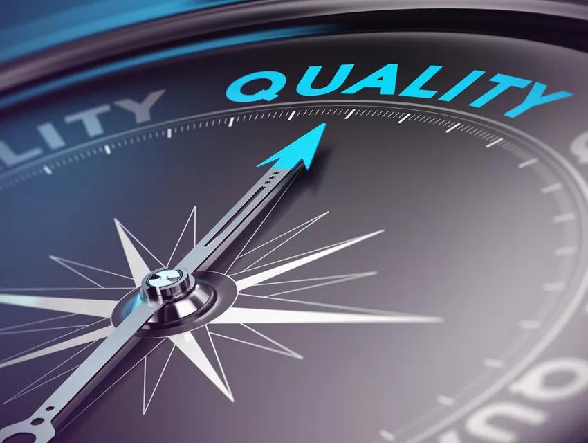 Kompass mit Pfeil, der auf das Wort "Qualität" ausgerichtet