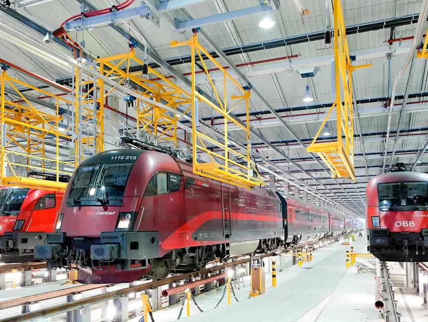 Mehrere OEBB Zuege bei Wartung in einer großen Halle