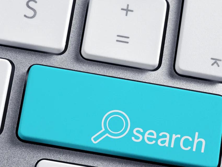 Eine türkise Suchtaste auf einer grauen Tastatur