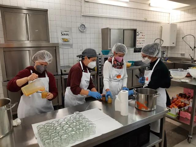 Petra Gruber und GS1 Mitarbeiter beim Marmelade einkochen