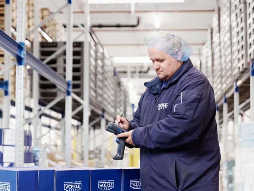Foto eines Woerle Mitarbeiters, der im Lager GS1 Strichcodes an einer Palette scannt