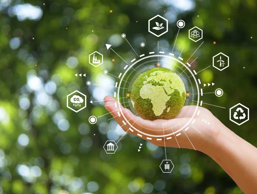 Foto zeigt den Planeten Erde in Grüntönen, der von einer Hand gehalten wird.