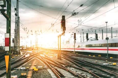 GS1 Standards ermöglichen die eindeutige Identifikation von Bauteilen Gleise und Gleiskreuzungen vor Bahnhof mit vorbeifahrenden Zug