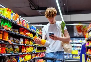 Foto eines Kunden im Supermarkt, der einen 2D-Code scannt
