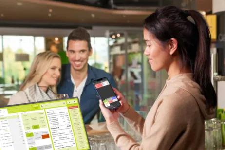 Fachkraft nutzt APRO Kassensystem am Smartphone und Bildschirm