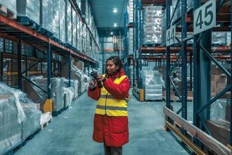 Mitarbeiterin im Lager scannt Produkte mit Strichcode-Scanner