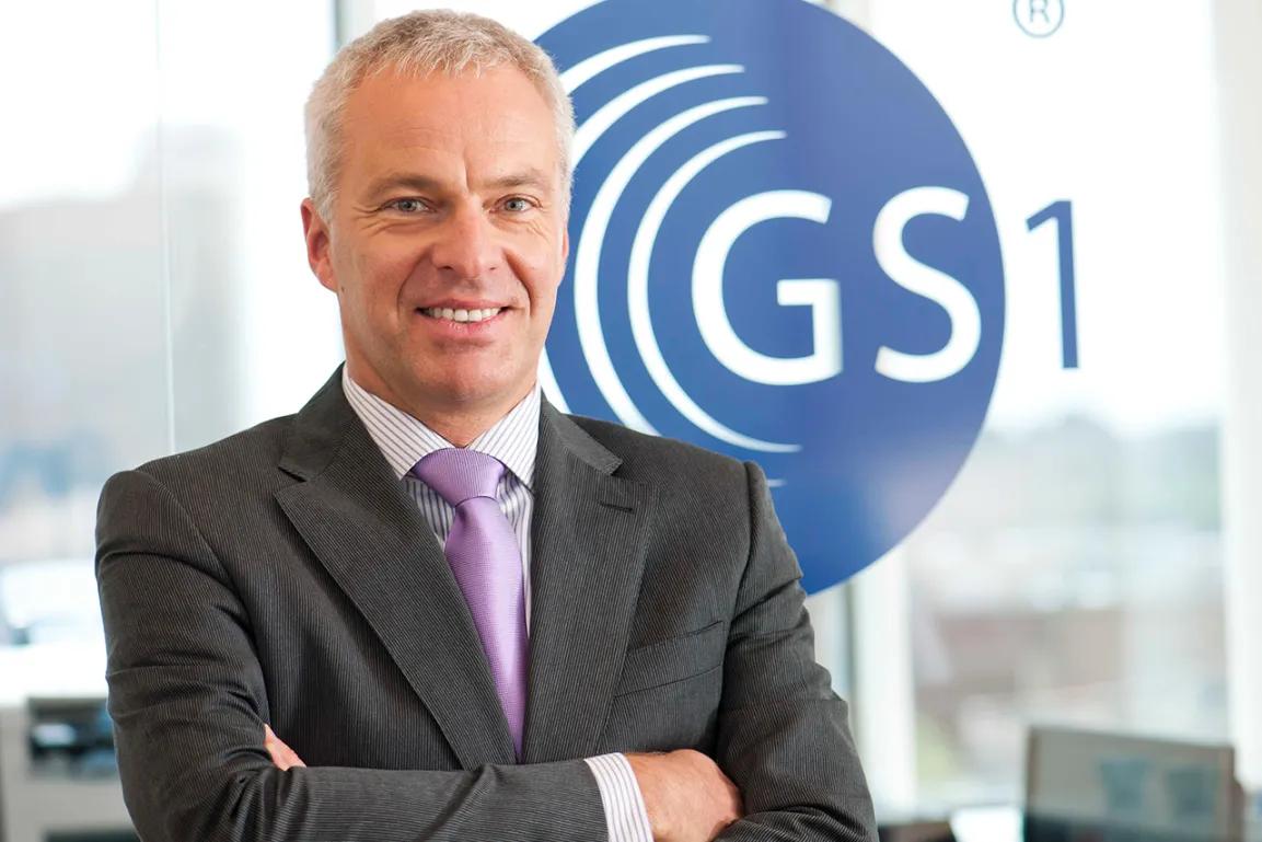 Foto von Enzo Blonk, Director Industry Engagement Technical Industries bei GS1 vor dem GS1 Logo