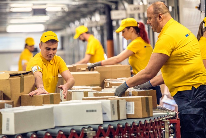 Mitarbeiter vom Paketdienst sortieren Pakete Pakete auf Förderband