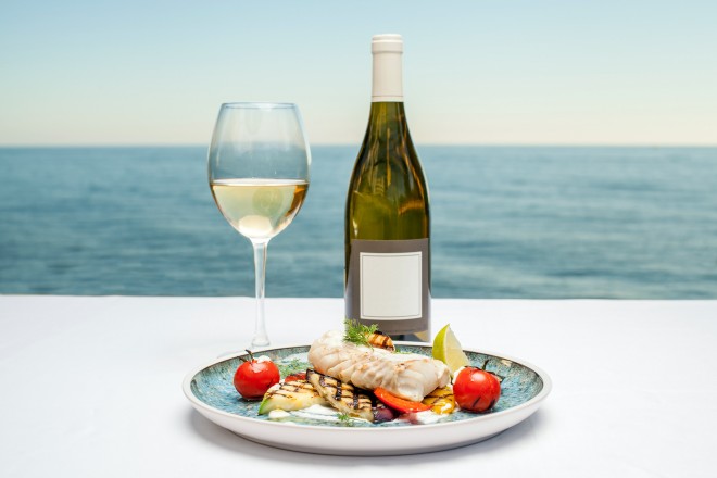 Weißwein und Fisch am Meer